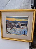 Front view of framed painting showing snowy farm landscape with barn, silos and fence against sunset.