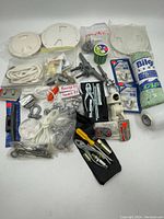 Top-down view of the entire lot showing various parts, tools, and packaging including wire spool, clamps, and plastic covers.