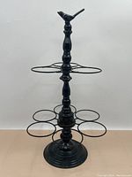 Full front view of the black metal umbrella stand showing the circular umbrella holders and the round base.