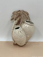 Front view of the vintage 1950s Beswick ceramic wall pocket vase showing the palm tree and two attached conga-shaped vases with embossed tropical designs.