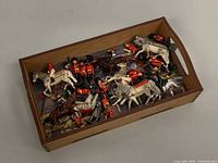 Wooden tray with a collection of vintage lead British guard soldiers and mounted officers, some paint chipping visible.