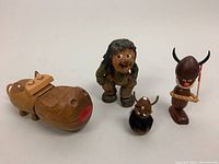 All four wooden carved items together; hippo trinket box, carved man, viking bust, horned figurine
