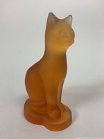 Front angled view of frosted orange crystal cat sculpture on integrated base.