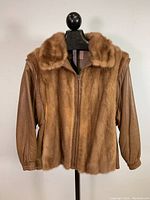 Front view of vintage ladies jacket with fox fur front and collar, brown leather sleeves, and zipped front closure