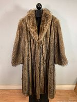 Front full view of vintage raccoon fur coat on mannequin showing length and fur texture