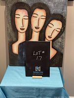 Photo of textured art canvas showing three women with closed eyes.