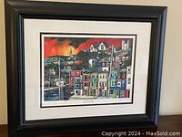 Front view of the professionally framed colorful giclee print art showing a scene of colorful houses under a vivid sky.