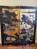 Full view of the four-panel folding privacy screen showing painted Japanese scene on front side with buildings, figures, trees and rocks under gold and natural sky backgrounds.