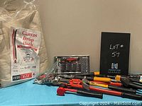 Photo shows assortment of garden and hand tools along with canvas drop cloths grouped on a cloth surface.
