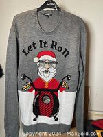 Front full view of large gray knitted Christmas sweater with Santa on motorcycle and 'Let It Roll' text