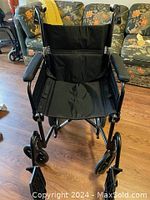 Front view of black fabric folding wheelchair showing seat and armrests