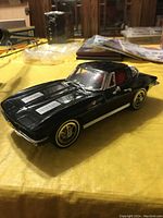Side view of the black Corvette car model telephone showing detailed car design and shape.