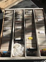 Overview of large cardboard box divided into four compartments, each densely packed with vertically stacked hockey cards separated by handwritten labels with player names starting with M.