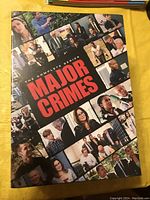 Front cover of Major Crimes The Complete Series DVD box set with collage of characters from the series and large bold red title.