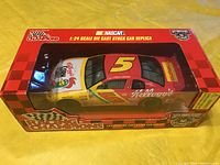 Side and top view of the diecast car inside its original Racing Champions box, showing Car #5 with Kellogg's Corn Flakes branding and NASCAR 50th Anniversary logo on packaging.