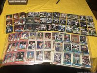 Overview of multiple sports cards laid out in clear plastic sleeves, showing various baseball players.