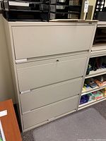 Front view of the 4-drawer metal filing cabinet, showing closed drawers with the lock in place.