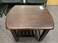 Top view of the hardwood side table showing the smooth dark brown stained surface with slight wear.