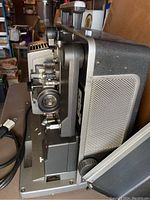 Side view of Bell & Howell 16mm projector showing lens, controls, and ventilation details.
