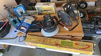 Overview of automobile tools and supplies including timing light, waxer, reels, jack, power washer, and boxed items