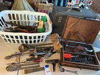 Overview of various hand tools laid out with two toolboxes in the background, showing the types and condition of tools.