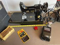 Singer sewing machine on base with foot pedal, attachments kit, needle pack, tape measure