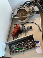 Photo of SkilSaw circular saw, Milwaukee hole shooter drill, and Sears socket set in metal case with sockets visible.