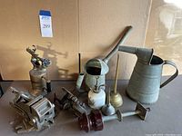 Full lot showing oil cans, atomizer, sharpener, blow torch, and insulator grouped on table