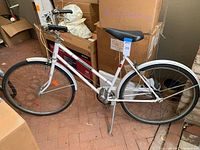 Full side view of white Huffy Mainliner 3-speed bicycle showing frame, wheels, and saddle with some visible rust spots.