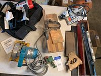 Craftsman finish nailer, Makita circular saw, Manning Bowman planer, level in wood case, small green clamp, back saws and miter box on table