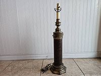 Full view of the tall brass table lamp showing the base, column and socket.
