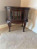 Full view of the cherry wood serving table with the door closed showing the ornate legs and carved detailing.