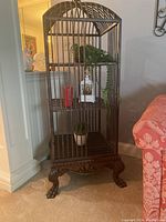 Front view showing overall structure, three interior shelves, carved base and claw feet