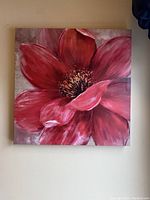 Front view of frameless wall art showing a close-up red flower with detailed petals and a textured center on a muted background.