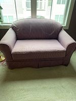 Front view of purple striped pull-out sofa bed with rounded armrests and removable slip cover.