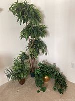 Set of three artificial plants including the tall tree with removable white lights, the palm-like plant, and the trailing leafy plant.