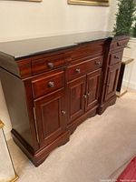 Front view of sideboard showing three top drawers and four lower cabinet doors under marble top