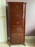 Front view of the tall dresser showing four drawers and brass hardware
