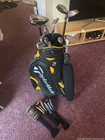 Full set of clubs standing in TaylorMade R5 bag on carpet