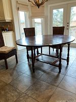 Full view of table open in dining area showing extended oval top and turned legs
