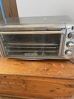 Front angle showing full toaster oven with glass door and racks inside