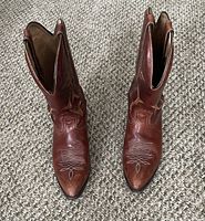 Pair of brown leather cowboy boots, top view showing pointed toes and stitching patterns.