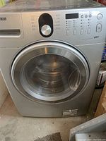 Front view of washing machine showing control panel, door, and exterior condition