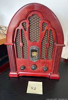 Front view of the antique style replica radio showing its wooden cabinet and mesh speaker grille.