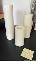 Three ivory battery operated candles of different heights arranged on a table.