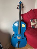 Front view of full size blue cello standing upright