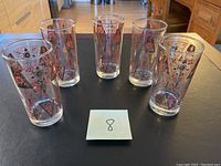 Six vintage highball glasses arranged on a table, showing overall condition and pattern.