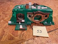 Entire assembled Hobbits hole set showing front and side with green and tan Lego pieces, including door and window details.