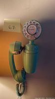Green rotary dial phone showing handset and rotary dial with area code 317 and number 742-8205.