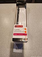 Full view of the towel bar in original box packaging showing brand, size, and collection.